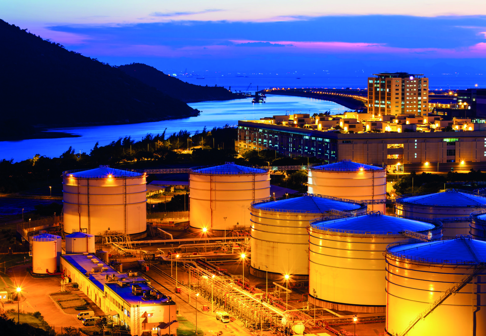 Night image of larger oil refinery with storage drums